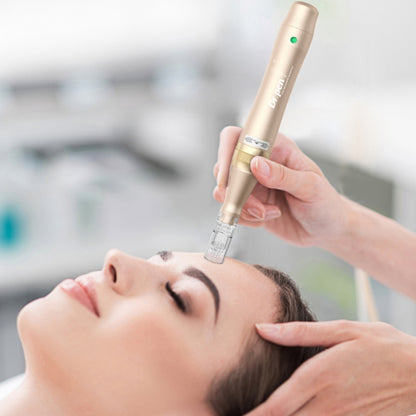 A person lies relaxed while a practitioner performs microneedling on the forehead with a gold-colored Dr. Pen M5. The practitioner holds the pen with both hands for precision.