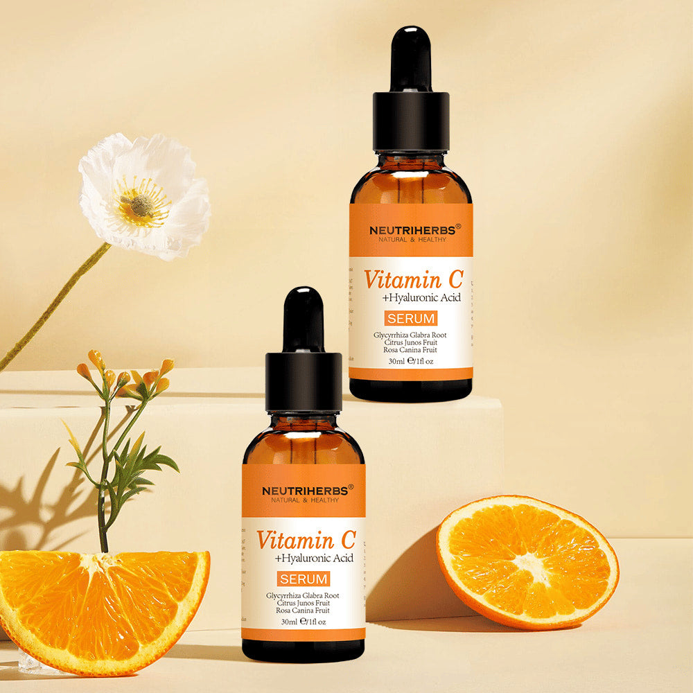 Neutriherbs Vitamin C + Hyaluronic Acid Serum 30 ml together with fresh oranges and flowers. Inspiring product image highlighting the serum’s vitamin C content for hydrated skin, enhanced radiance, and a more even skin tone.